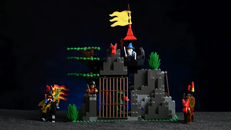 The complete LEGO Castle Dark Dragon's Den (6076) set from 1993, fully built after 33 years, with its rocky den, barred dragon cage, wizard's tower, and mounted Dragon Knights
