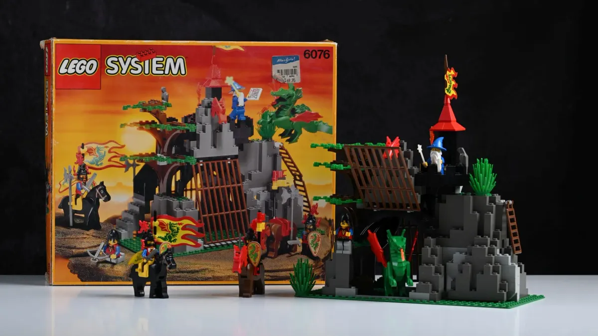 The original 1993 box for LEGO Castle Dark Dragon's Den (6076) next to the fully built set, still with its original price sticker