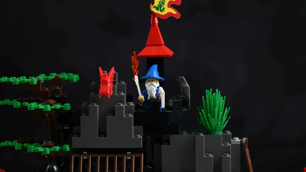 Close-up of Majisto the wizard minifigure atop the tower of LEGO Dark Dragon's Den (6076), holding a glow-in-the-dark wand next to a parrot