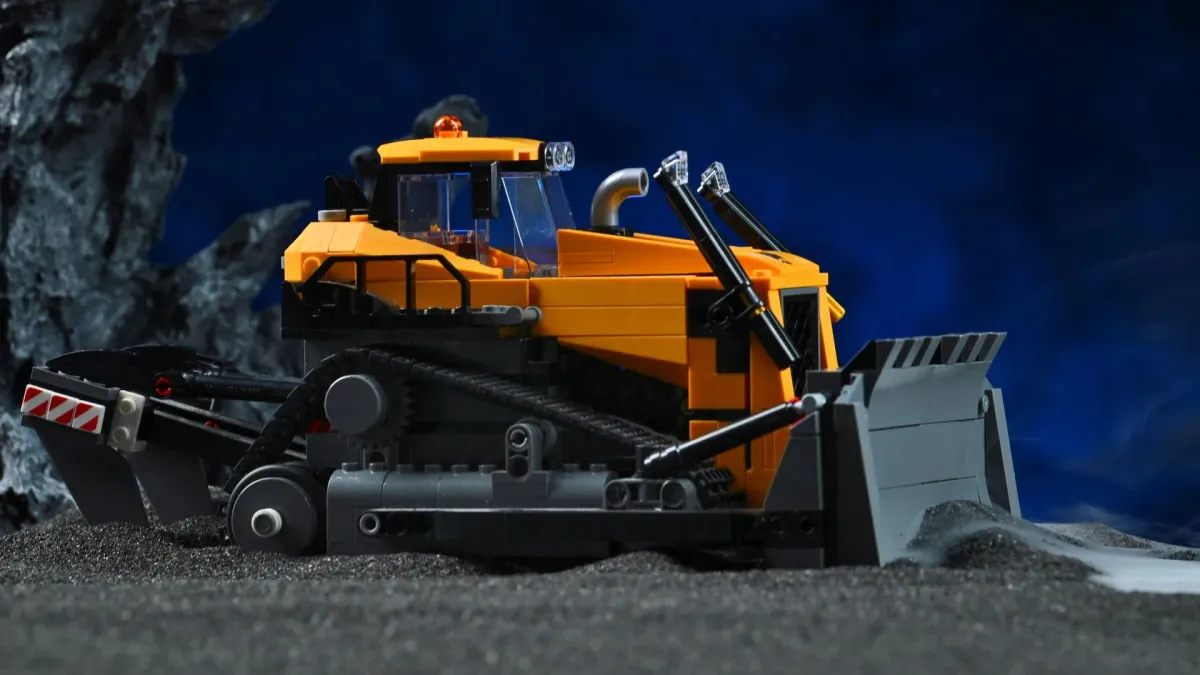 Close-up of the LEGO City Yellow Bulldozer (60466) blade and tracks, staged with rock and smoke props