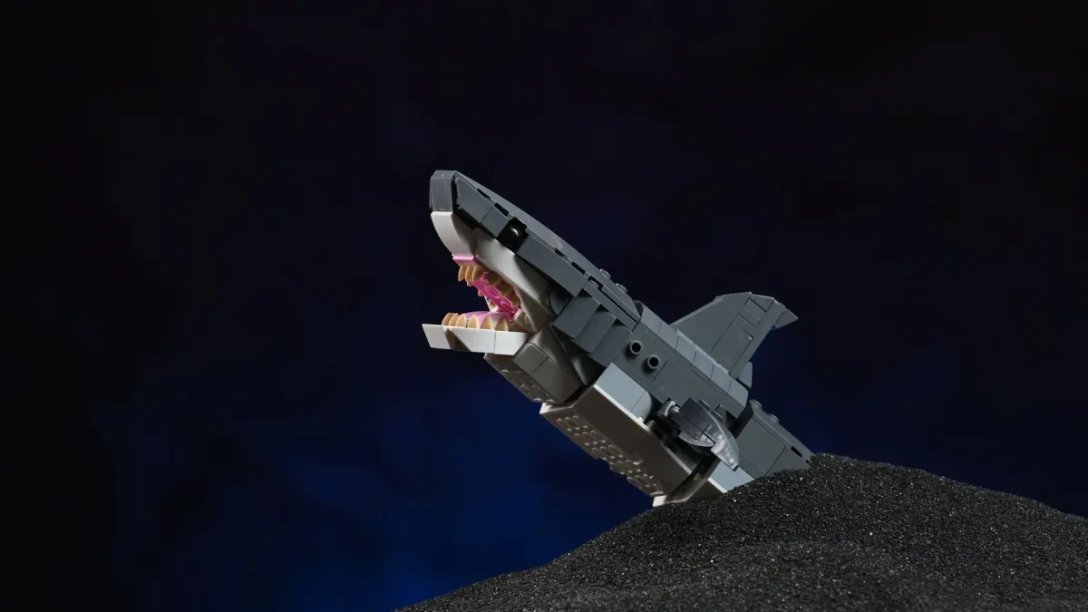 The posable LEGO Creator Fierce Shark (31381) build, jaws open, breaching a dark sandy seabed