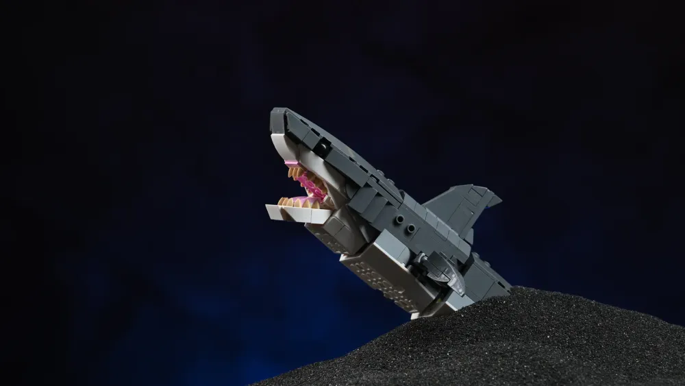 The posable LEGO Creator Fierce Shark (31381) build, jaws open, breaching a dark sandy seabed