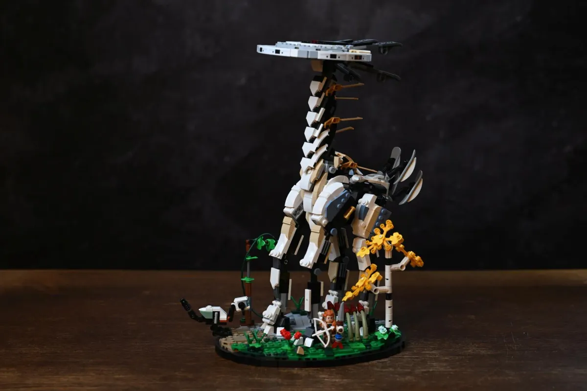 The complete LEGO Horizon Forbidden West Tallneck (76989) on a wooden shelf, showing the full height from the scenic base to the disc-shaped head