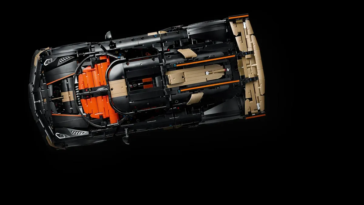 Overhead view of the LEGO Technic Koenigsegg Sadair's Spear 42232 with the bodywork open, showing the orange interior, the V8 piston engine and the transmission running down the centre