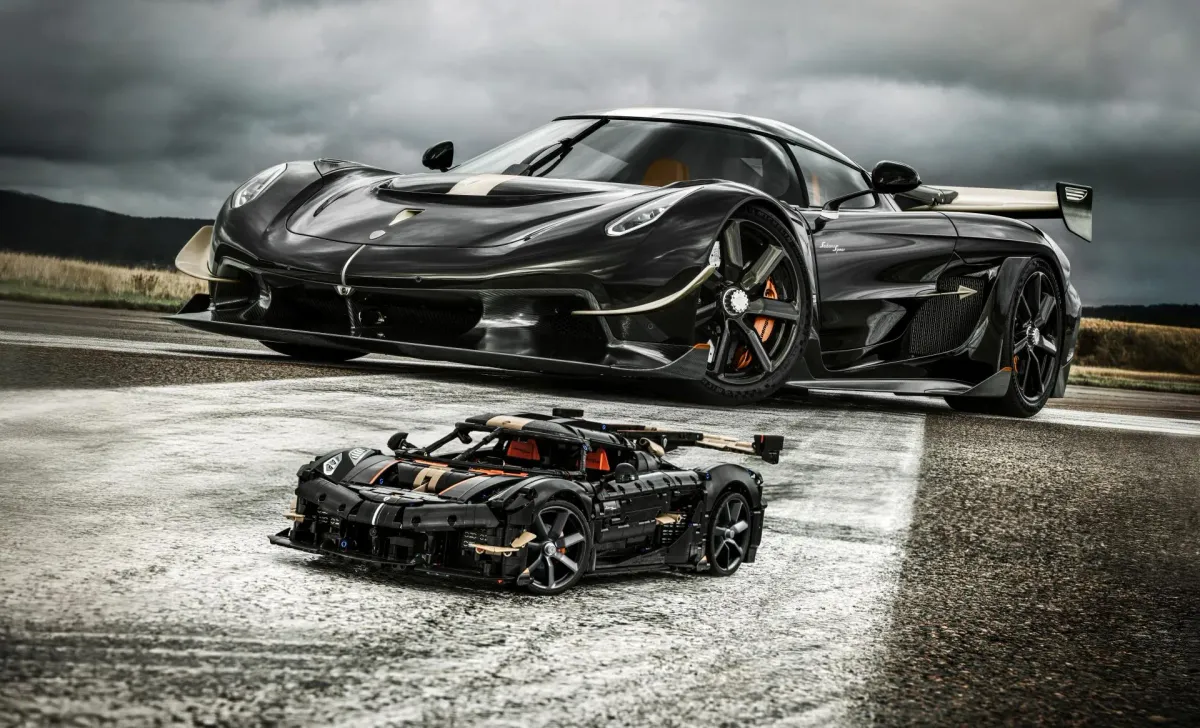 The real black Koenigsegg Sadair's Spear photographed next to the 1:8-scale LEGO Technic model 42232 on wet tarmac
