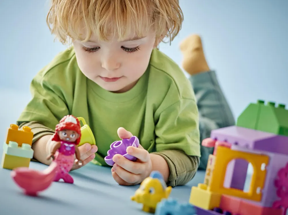 A toddler playing with LEGO DUPLO figures - official LEGO lifestyle photo
