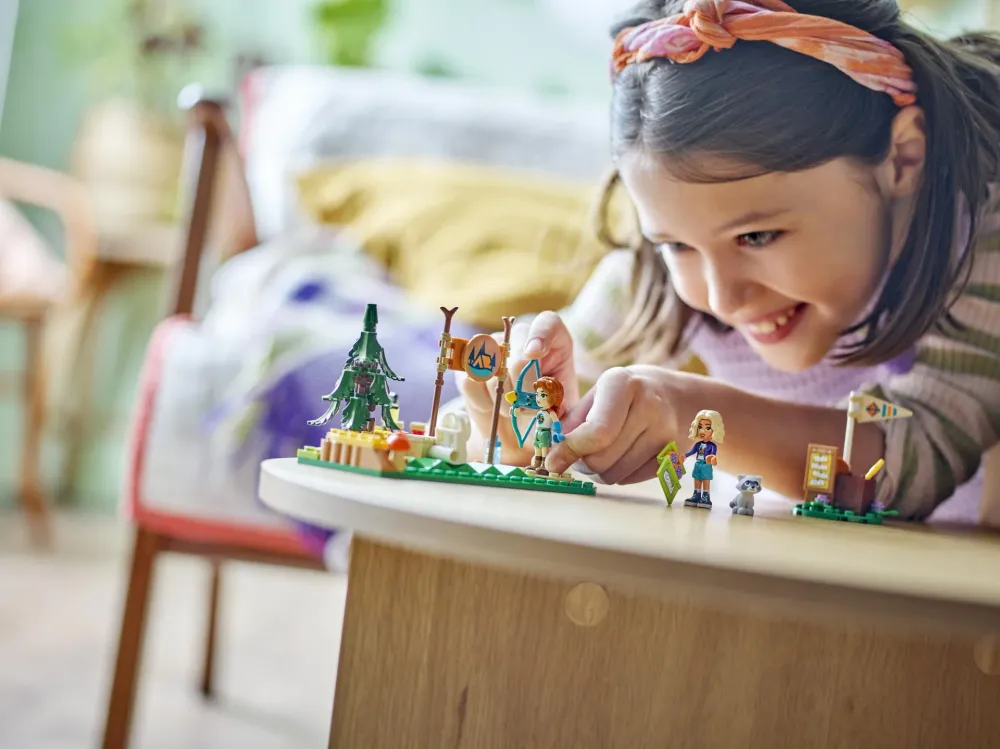A girl building a small LEGO nature set on a round table - official LEGO lifestyle photo
