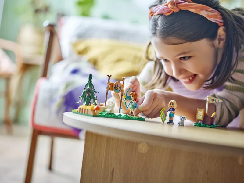A girl building a small LEGO nature set on a round table - official LEGO lifestyle photo