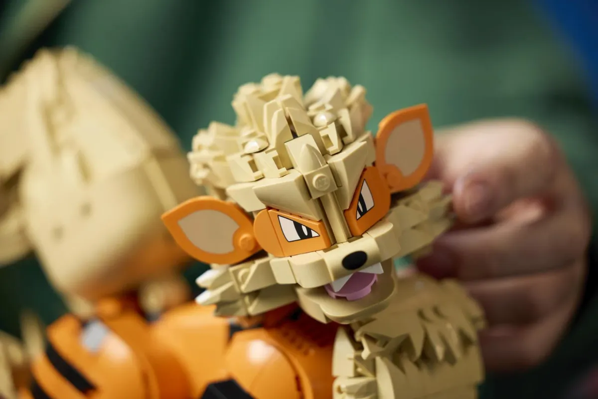 Close-up of the LEGO Arcanine head showing the printed eyes, orange face, open mouth and layered cream brick-built mane