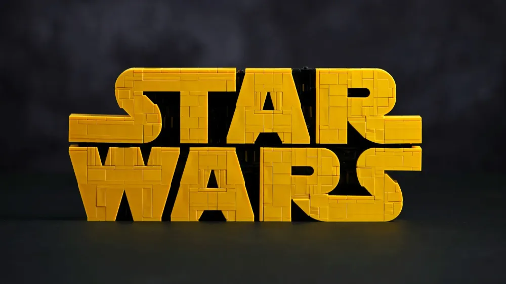 The finished LEGO Star Wars Brick-Built Star Wars Logo (75407) in yellow bricks against a dark background