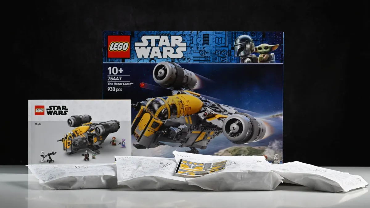 The LEGO Star Wars Razor Crest (75447) box, instruction booklet and numbered bags laid out on a table before the build