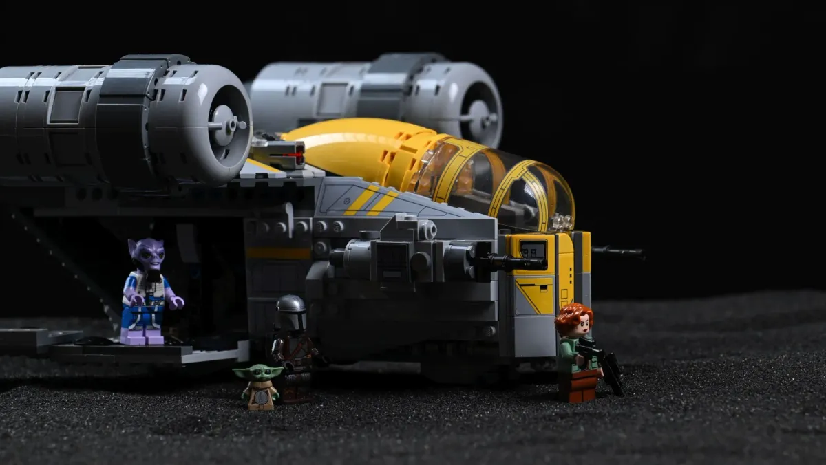 Close-up of the LEGO Star Wars Razor Crest (75447) engine and cockpit detailing with Zeb Orrelios, the Mandalorian, Grogu and a Rebel fighter standing beneath the open hull bay