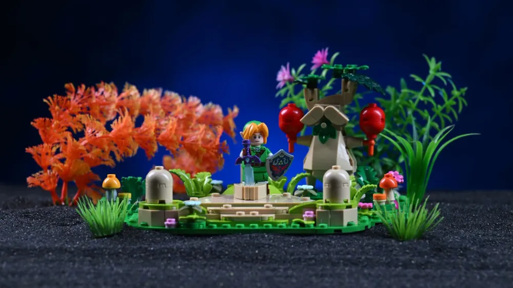 The Link minifigure with the Master Sword and Hylian Shield in front of our in-progress build of the LEGO Zelda Great Deku Tree (77092), staged with extra decorative greenery