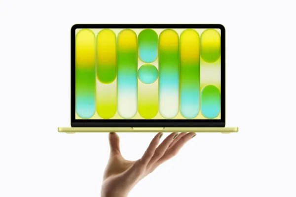 MacBook Neo in multiple colors on a wooden desk