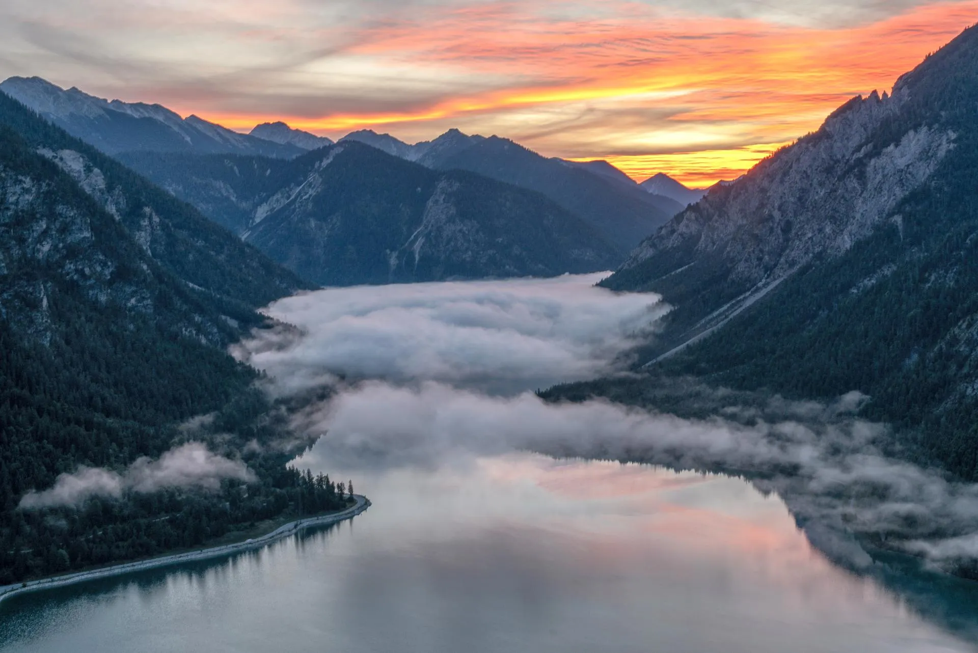 Aerial view of Plansee in Tyrol at sunrise with fog filling the valley below the mountains, shot with the Nikon Z8 and NIKKOR Z 24-70mm f/2.8 S