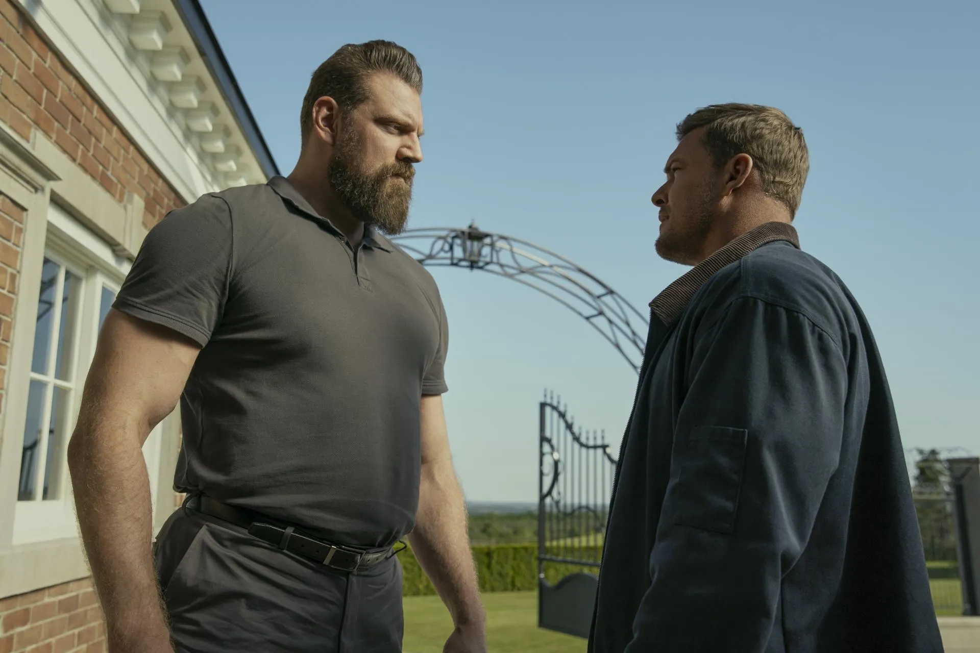 Olivier Richters as Paulie squaring up to Alan Ritchson as Jack Reacher outside the Beck estate in Reacher season 3