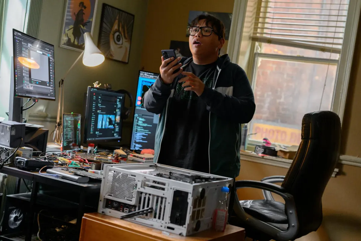 Ned Leeds working at his multi-monitor tech setup used to build the Spidey Tracker in Spider-Man: Brand New Day